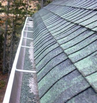 Close-up of missing and damaged shingles on a roof.